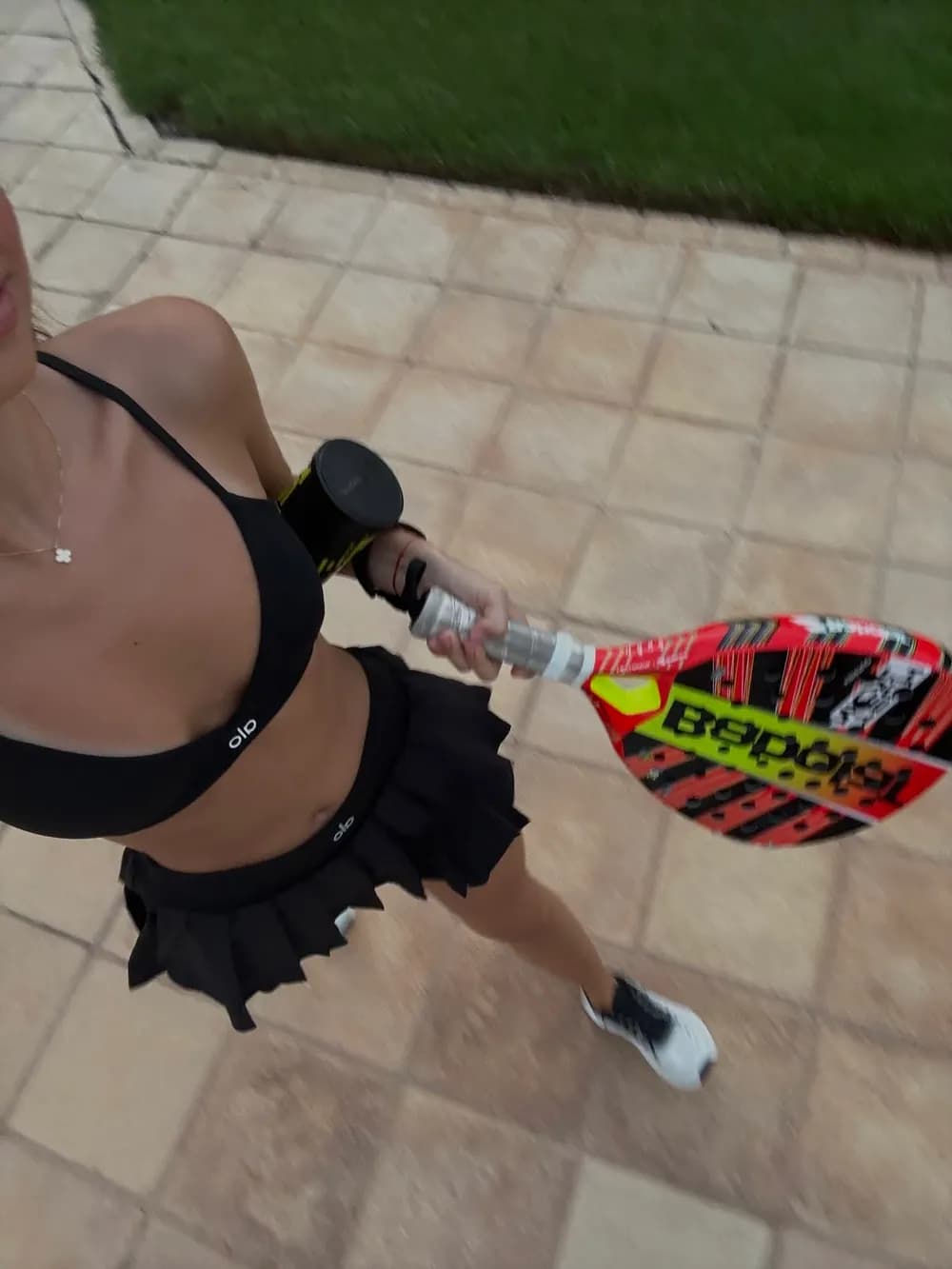 Black sports bra and pleated skirt on the way to padel