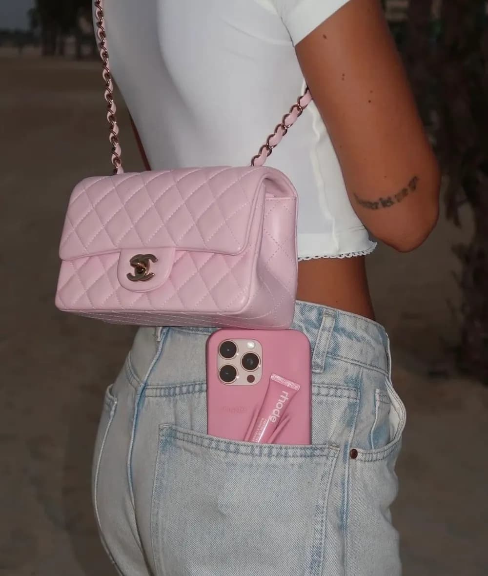 Pink mini flap bag with light denim and a white crop top