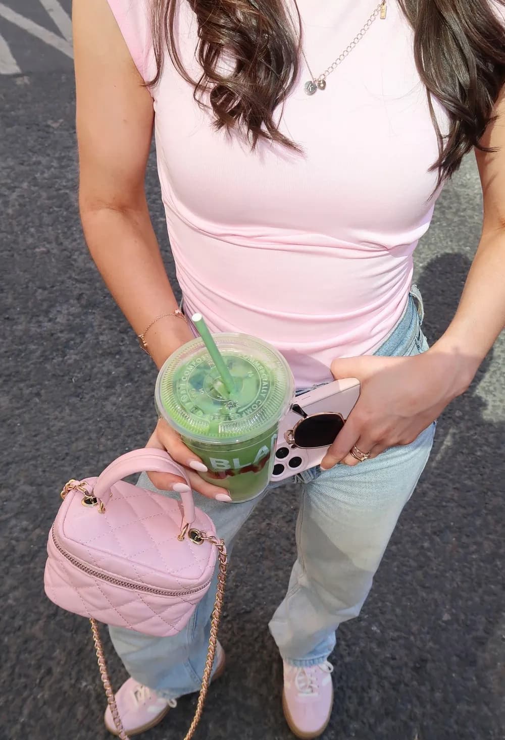 Pink top, light jeans and a pink quilted vanity bag